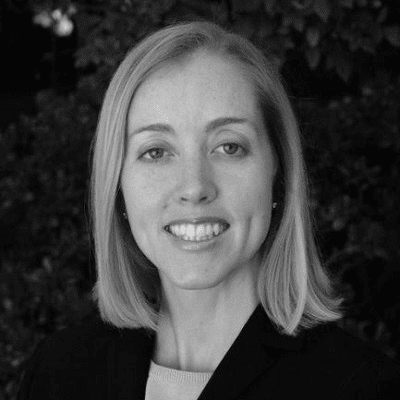 A black and white photo of a woman smiling.